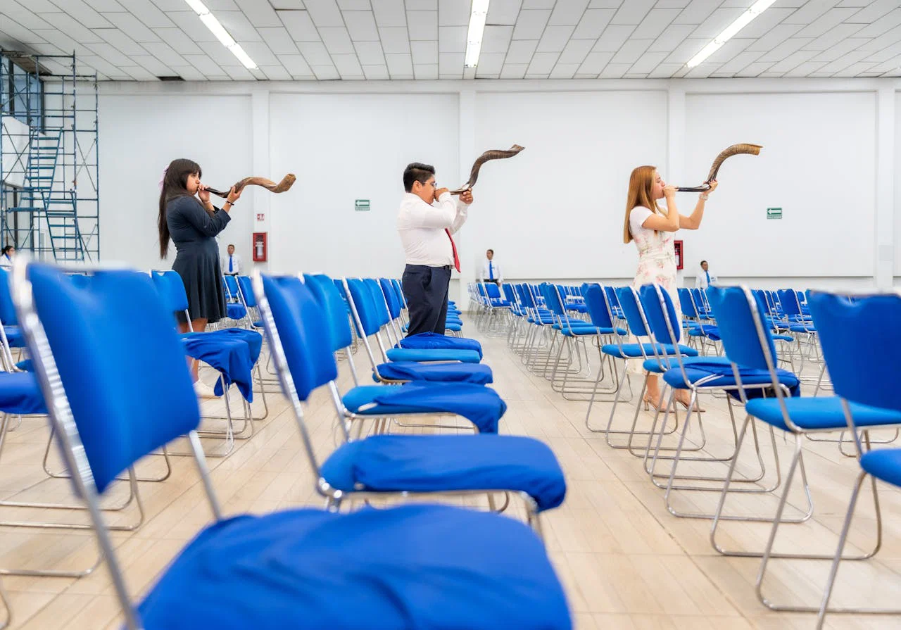 People playing shofars in a spacious indoor auditorium in Ciudad de México.